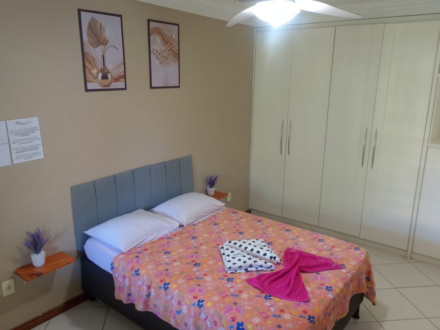 Quarto de casal com cabeceira estofada, guarda-roupa amplo e ar-condicionado